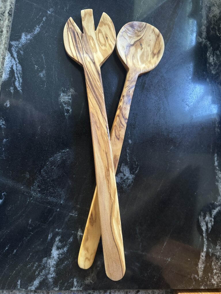 Finished olivewood salad spoon and fork showing the grain of the wood
